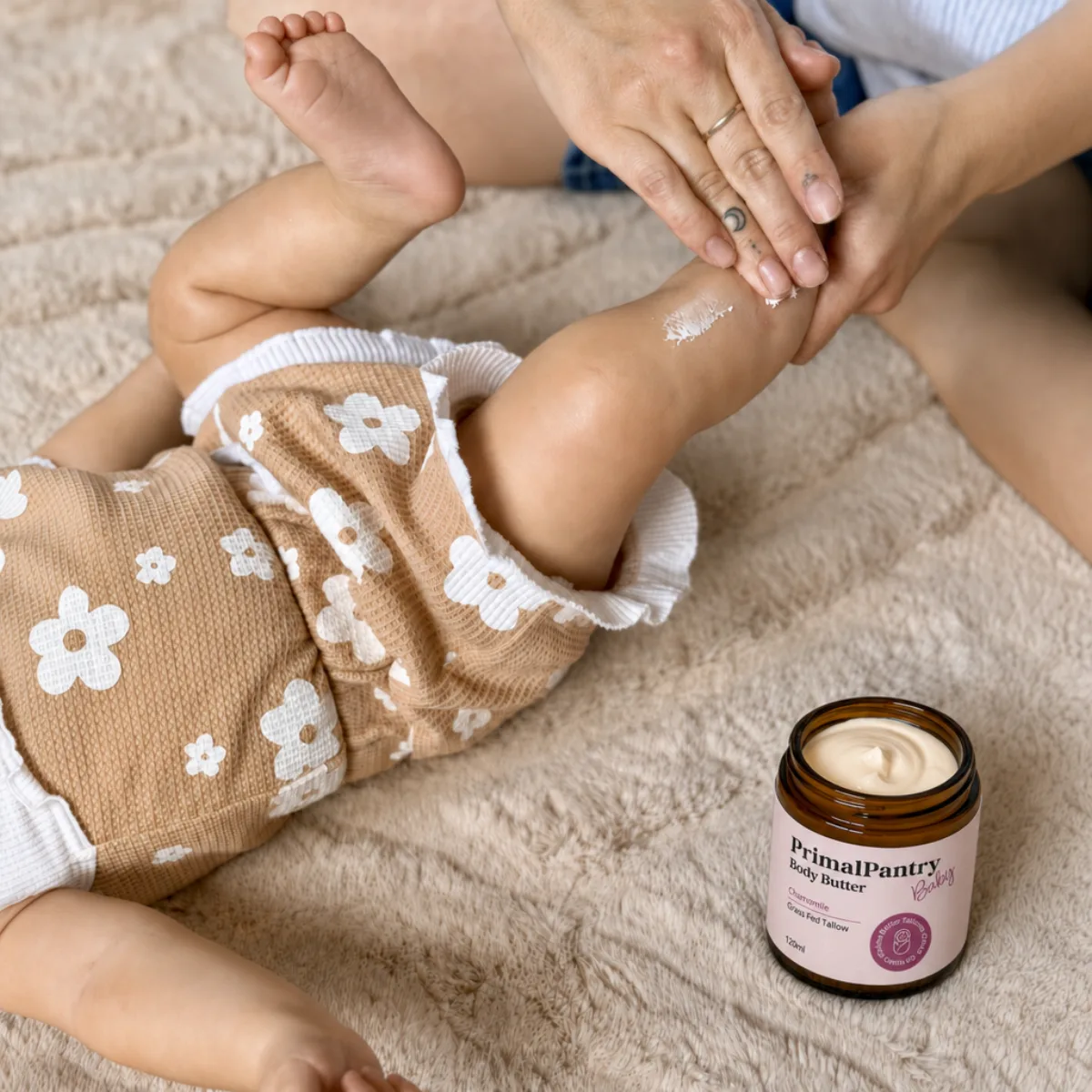 A parent spreading Tallow Baby Butter on a baby's leg