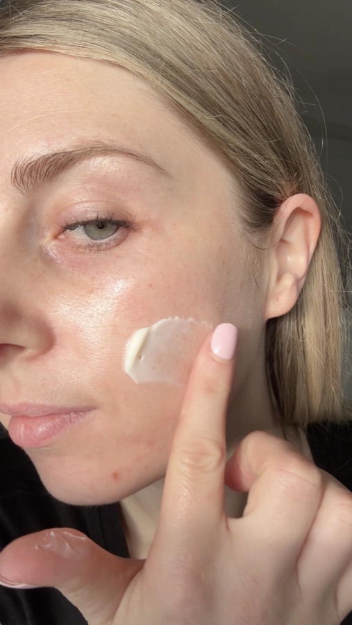 A swatch of pearl-white day cream on a customer's cheek