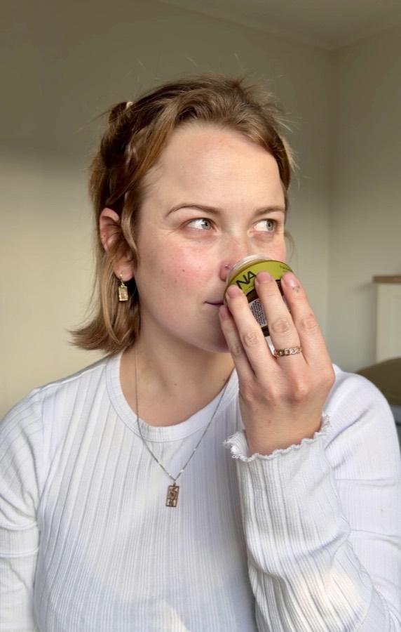 A customer holding the jar to her nose