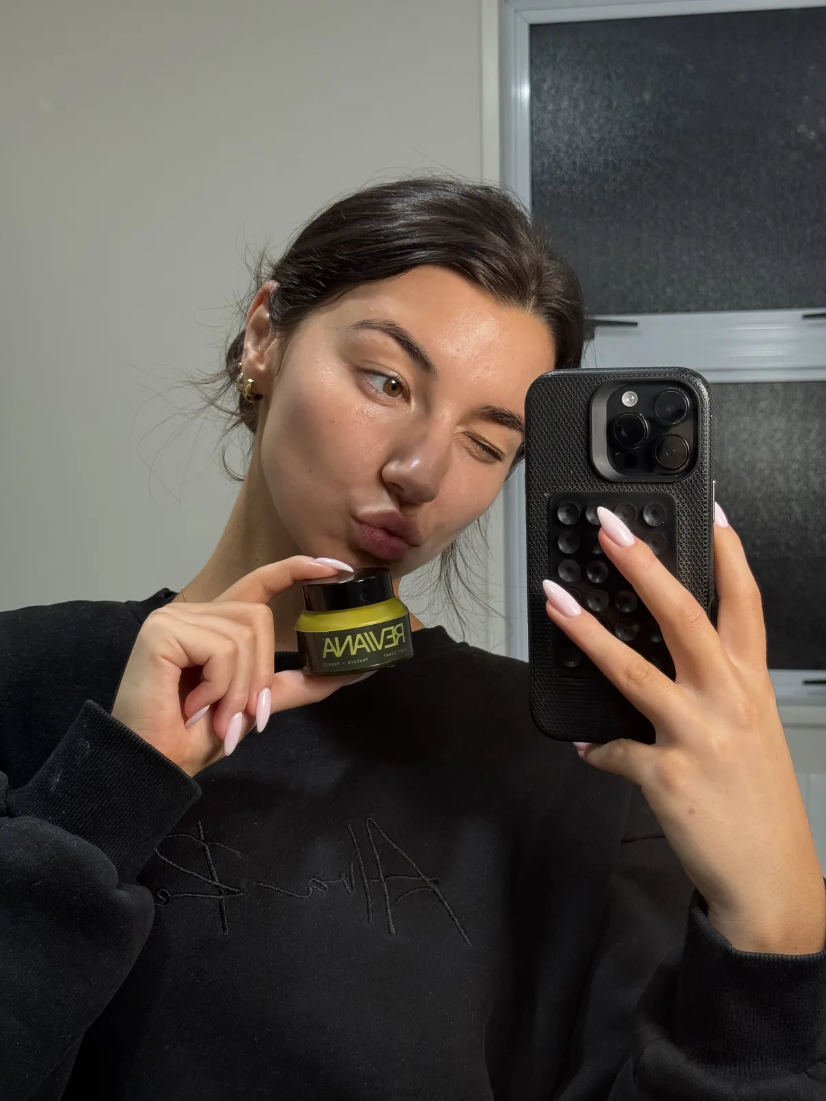 A customer with the Reviana night cream at the bathroom mirror